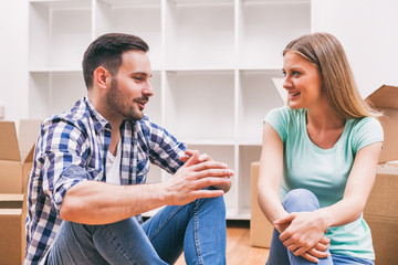 Young couple is moving in their new home. It's time for unpacking. 