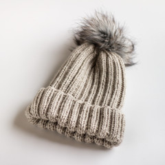 Fototapeta na wymiar Handmade knitted winter hat with pom pom on white background.