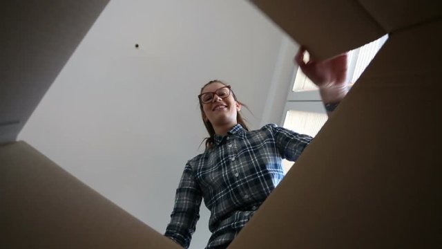 Hipster girl opens cardboard box