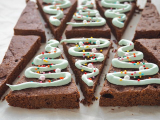 Triangle brownie dessert. Preparing Christmas treat. Decorating chocolate cake as Christmas tree. 