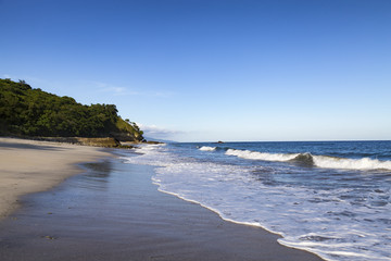 Afternoon light and small waves on an empty beach in Paga, East Nusa Tenggara, Indonesia.