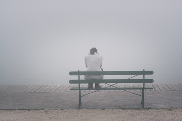 Depressive Frau auf Bank sitzend - obrazy, fototapety, plakaty