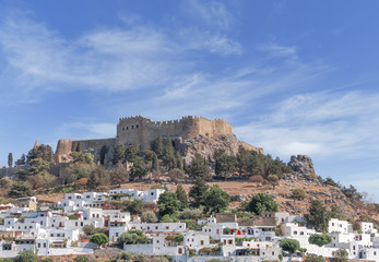 Fototapeta na wymiar Castle view Acropolis of city Lindos of Rhodes island with big blue clean sky