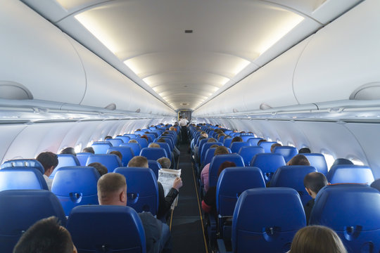 Interior of airplane with passengers on seats.