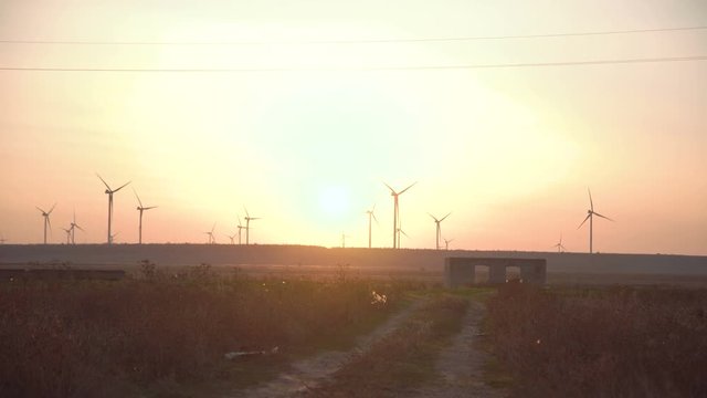 Turbines spinning on wind farm at sunset