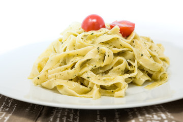 Pasta with pesto sauce and nuts on a the table