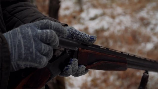 Hunter charges a hunting rifle with cartridges