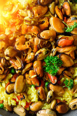 Traditional spanish seafood paella in pan rice, peas, shrimps, mussels, squid on light grey concrete background. Top view, copyspace