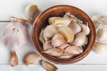 Organic grown garlic in a wooden bowl on a white background