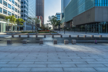 empty pavement and modern buildings in city.