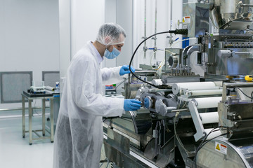 factory worker is configuring the machine