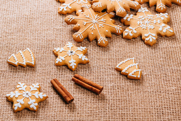 Christmas gingerbread cookies homemade and New Year decor on table with burlap tablecloth. Merry Christmas postcard.