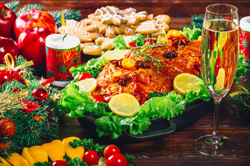 Christmas table dinner time with roasted meats decorated in Christmas style with glasses champagne. Background thanksgiving. The concept of a family holiday, delicious food.