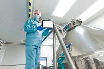 scientist show empty tablet near steel tank