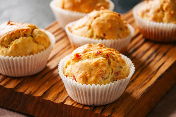 Homemade muffins with bacon and cheese on a black slate background. Healthy snack or breakfast meal.