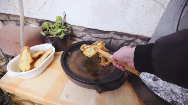 Person POV removing fried dough from oil 4K