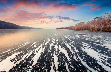 Picturesque winter sunset on the frozen lake.