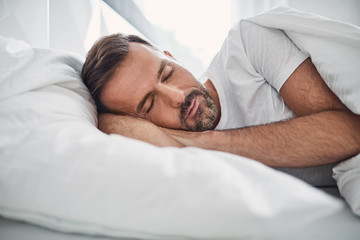 Serenity concept. Handsome man sleeping in a bed
