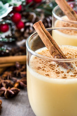 Homemade eggnog with cinnamon on wooden table. Typical Christmas dessert.