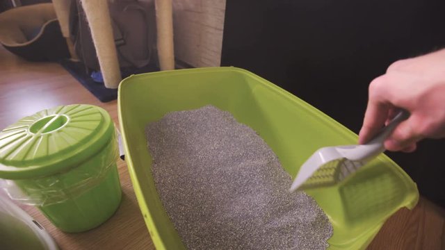 Preparing cat toilet sand with spatula POV 4K