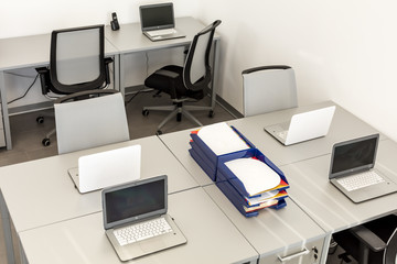 Modern office space, with desks and laptops.