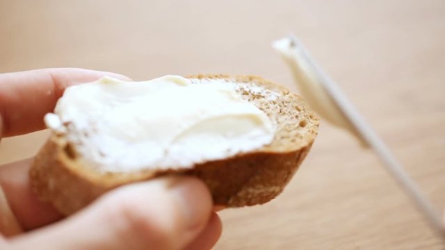 Spreading cheese on bread slice
