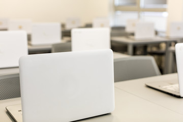 Modern office, work desks with laptops. In depth photography.