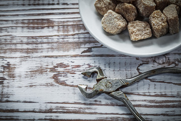 Vintage sugar cubes pliers plate on wooden board