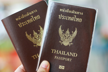 Two Thai passports in hand, travel concept