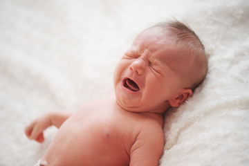 cute crying newborn baby at home