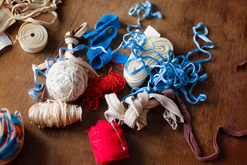 A bunch of colorful red, blue and white old vintage ropes on a brown wooden table with a loose lacquer.
