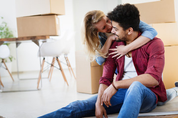 Young couple Moving in new home and unpacking carboard boxes - obrazy, fototapety, plakaty
