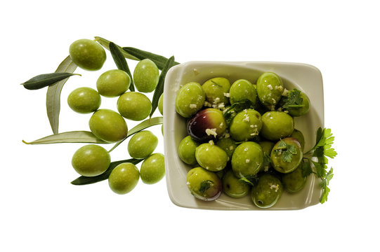 Olives seasoned with oil, salt, parsley and garlic on a white background