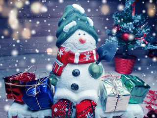 christmas snowman decoration and snow on wooden background