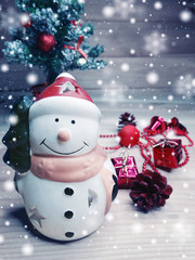snowman christmas decoration and snow on wooden background