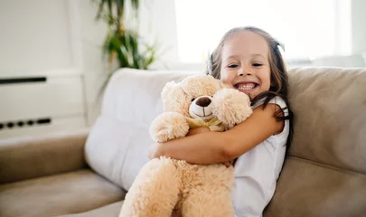 Fotobehang Cute little girl playing with teddy bear © NDABCREATIVITY