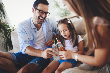 Happy family drinking juice together in their house