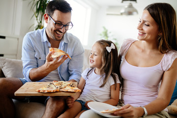 Happy family sharing pizza together at home
