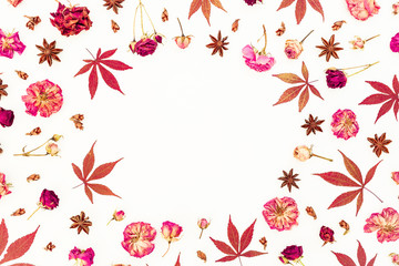 Autumn round frame of red maple leaves and dried roses on white background. Flat lay, top view.