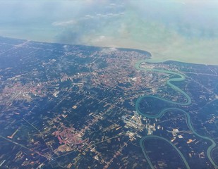 Outside the plane's window. Aerial view of agricultural field, river and sea.