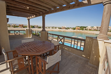 Terrace balcony with chairs and table at tropical luxury apartment