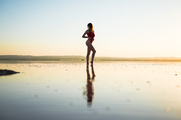 Fototapeta premium Young girl in red swimsuit at the beach