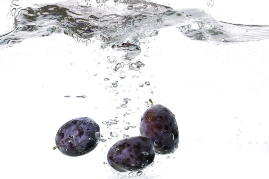 Plums falling into water