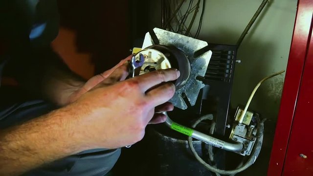 Male hands assemblying gas burner back together after service. Inserting as mixing nozzle back in burner tube. In slow motion hd.