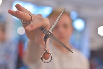 Hairdresser's hands cutting hair. Scissors in the hands of a barber