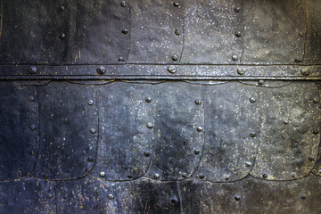 Ancient fortress gates made of armor and metal. Fortress "Oreshek", Europe, Shlisselburg, 700 year old castle. Black aged metal background of forged plates with rivets.