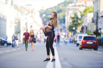 Beauty Glamor young Woman looking with interest goes. Long hair. Fashionable lady with a beautiful hairdo, makeup. against the background of new buildings in the city. fashionable dress. Copy space