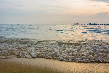Artistic photo. Close-up on a wave withdrawing on the sand of a beach in the sunset