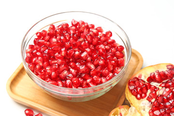 pomegranate seeds in glass bowl isolated on white background