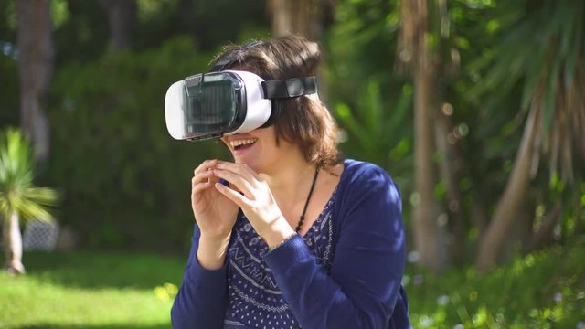 Young woman using VR glass. Beautiful girl, millennial generation, is experimenting with virtual reality, astonished, enjoying and smiling